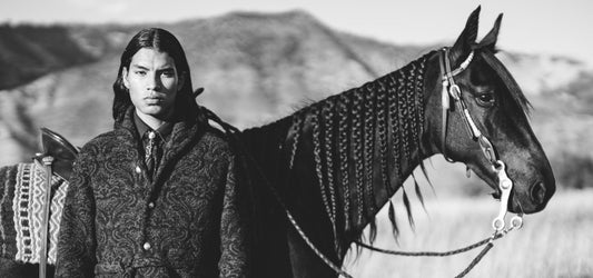 RRL by Ralph Lauren model in heritage knit and Western tie beside saddled horse, black-and-white ranch portrait reflecting American frontier style