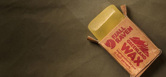 Fjallraven Greenland Wax on a fabric surface, used for waterproofing garments
