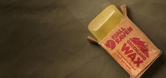 Fjallraven Greenland Wax on a fabric surface, used for waterproofing garments