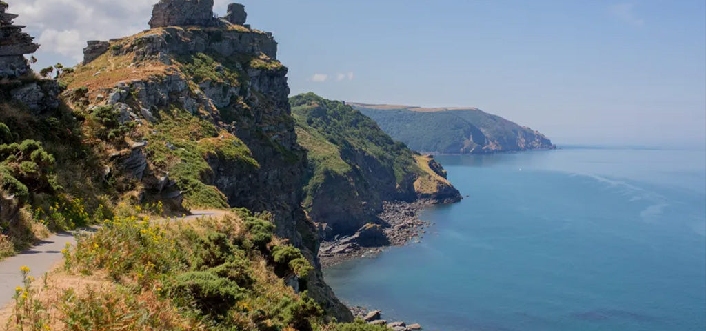 Clifftop walking path overlooking the North Devon coast with sea views and rugged headlands on a sunny summer day