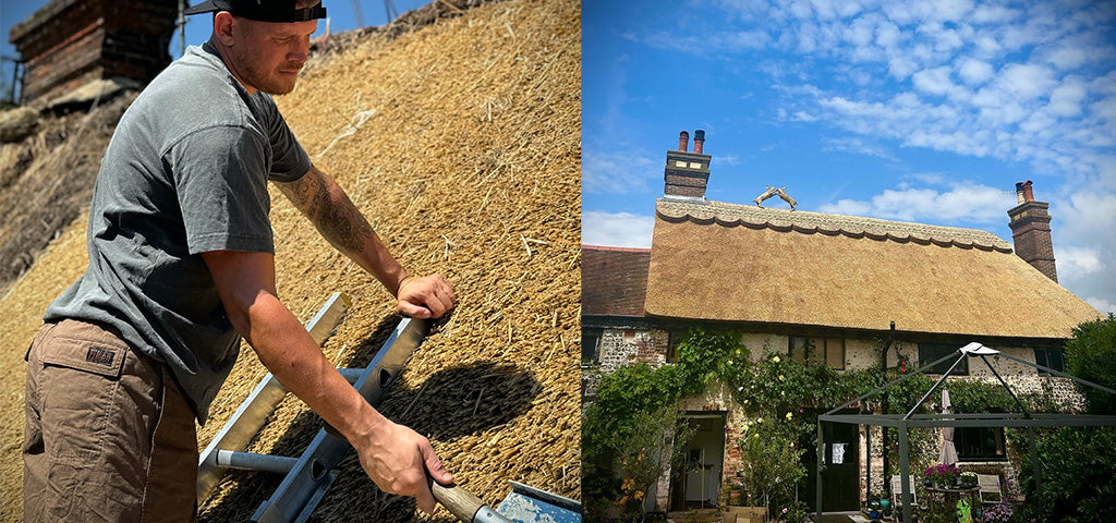 Thatcher Shane Stevens working on a traditional thatched roof, with a completed cottage showcasing his craftsmanship under a blue sky.