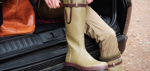 Person putting on a pair of Green Chameau Boots