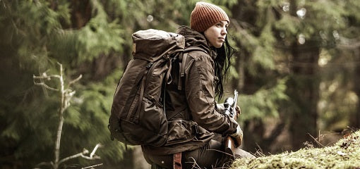 Woman Hunter in Woodland with Fjallraven Backpack and Shotgun
